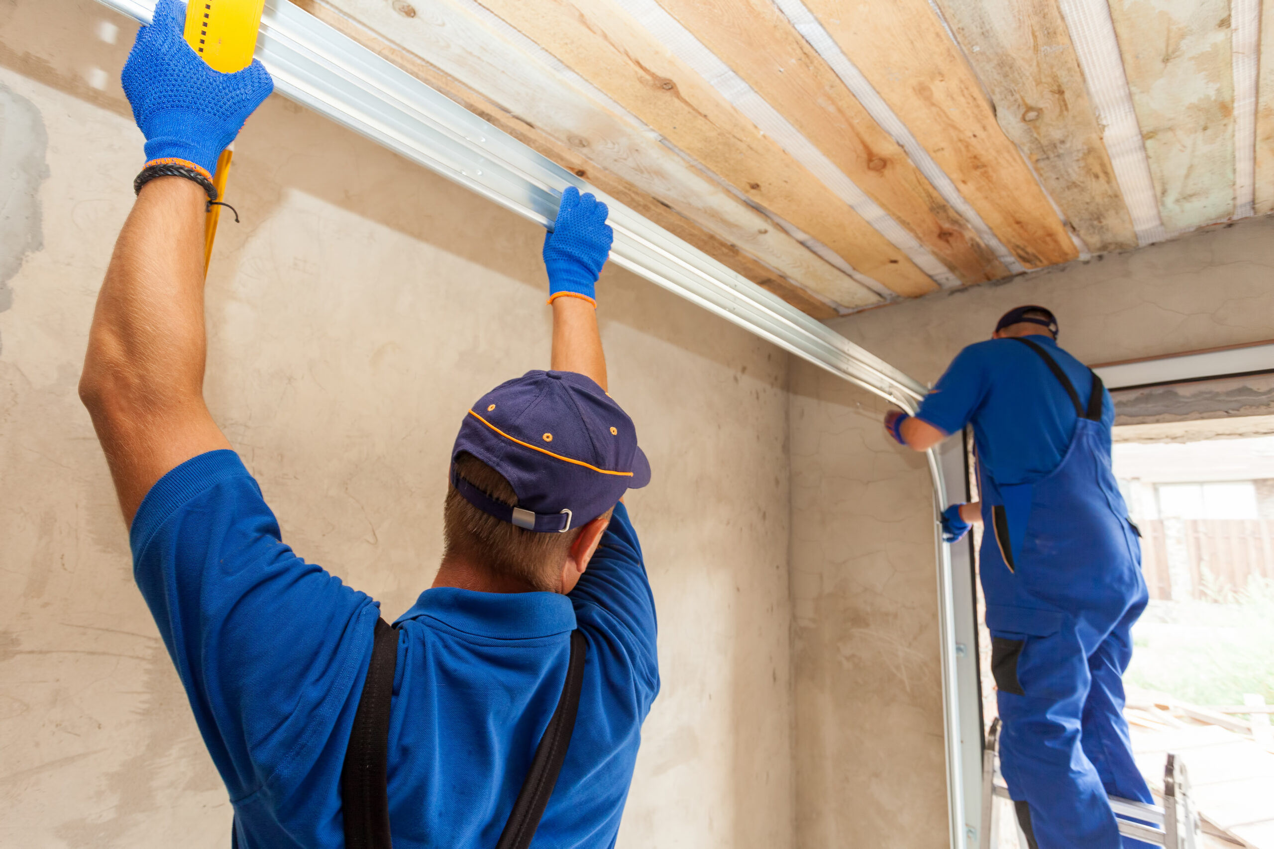 two construction workers in a blue shirt are repairing garage