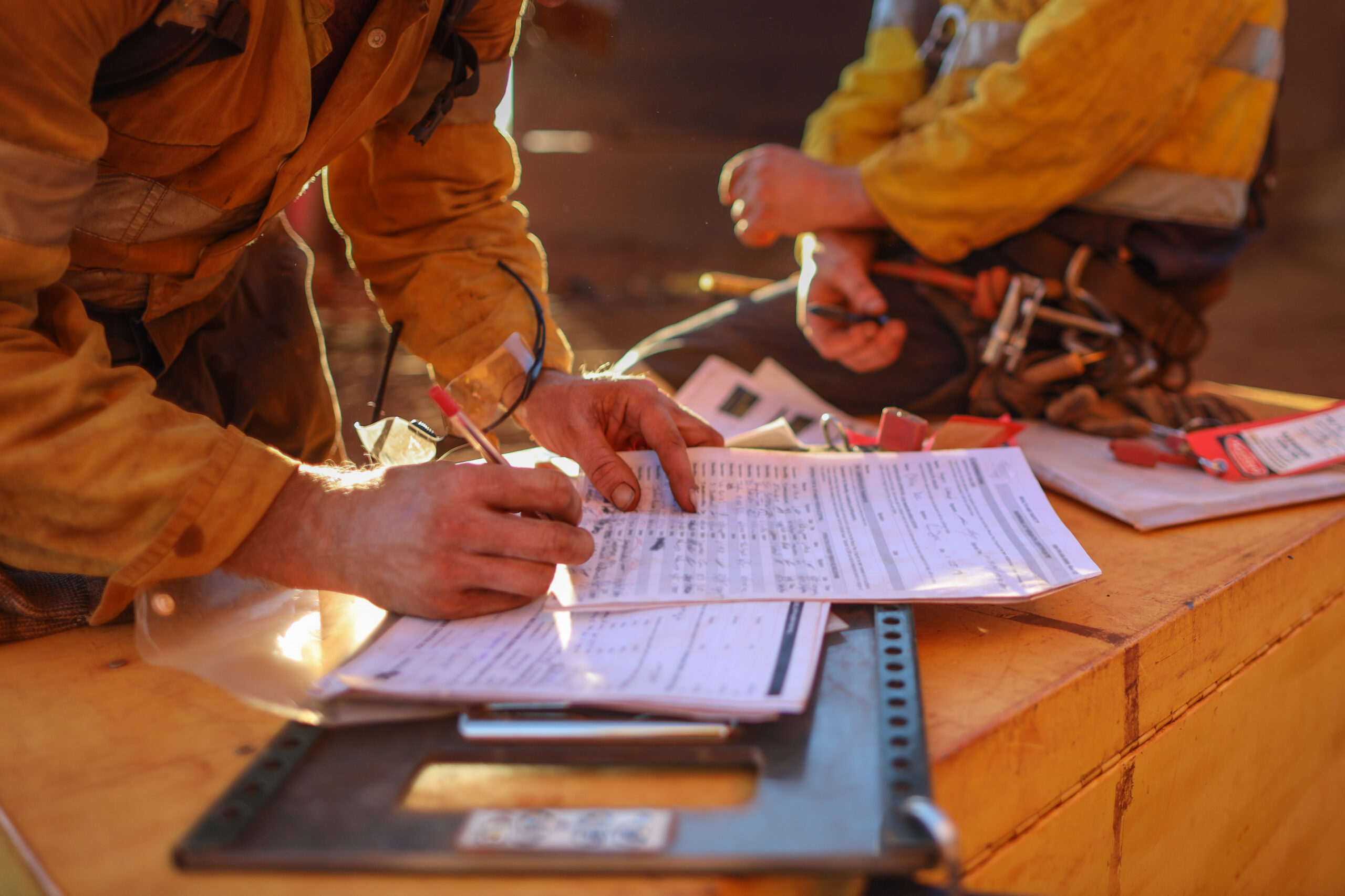 a construction worker is signing papers at the desk,