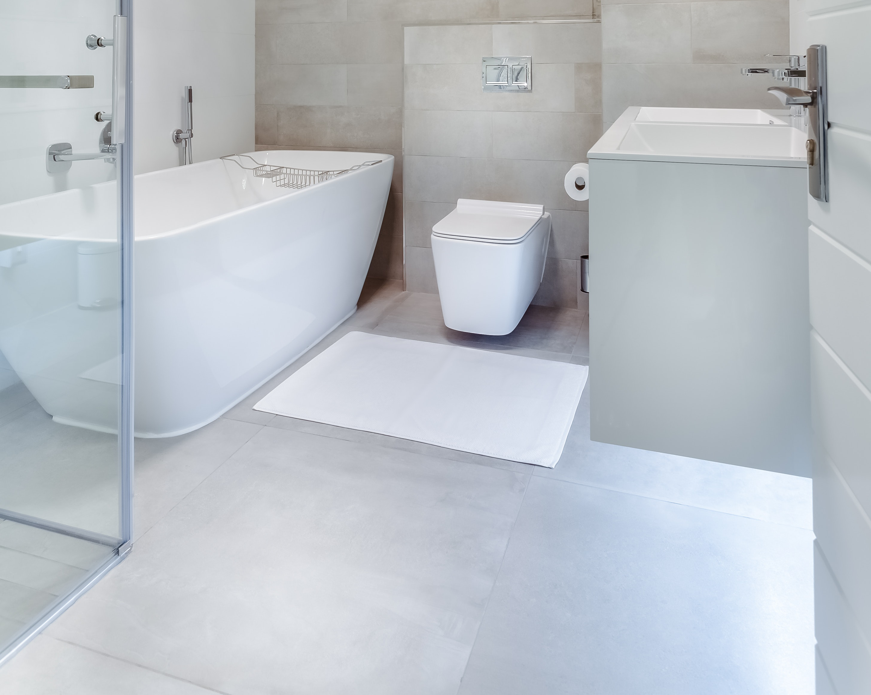 a white tub and white toilet on an empty floor