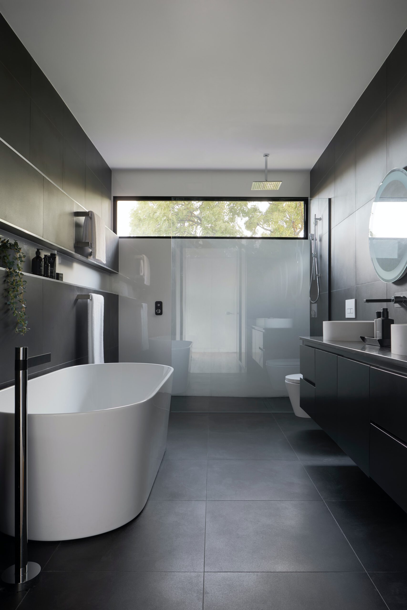 an open bathroom with black walls and a white bathtub