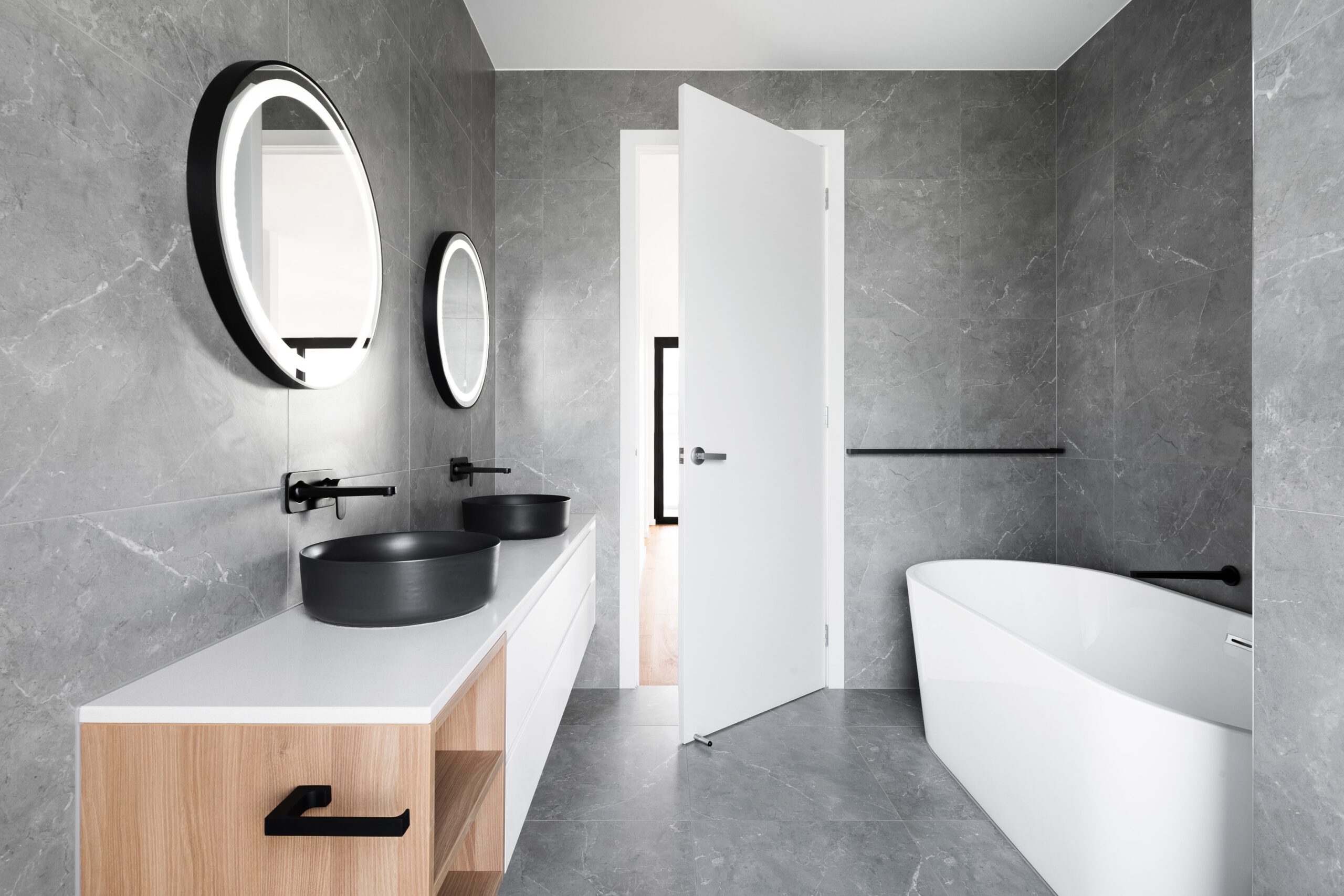 an innovative modern bathroom with grey walls and furniture, in the style of ethereal minimalism, rounded forms, simplicity, monochromatic color palettes, anti-clutter, minimalist designs, light gray and black, expansive spaces, marbleized